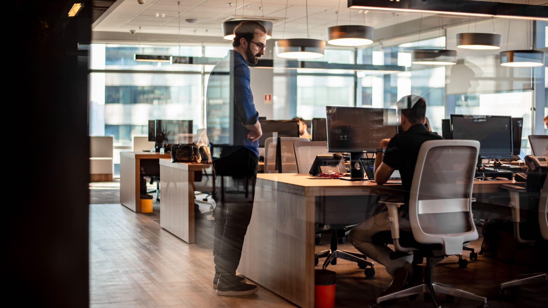 Espaço de escritório moderno com profissionais trabalhando em mesas com computadores