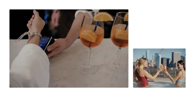 Person, die ein tragbares Gerät verwendet, um an einer Bar zu bezahlen, zwei Gläser Orangencocktail, zwei Personen, die mit Getränken in einer Stadtlandschaft anstoßen.