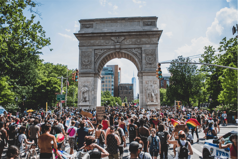 Folla che si riunisce in una protesta sotto un arco con cieli sereni