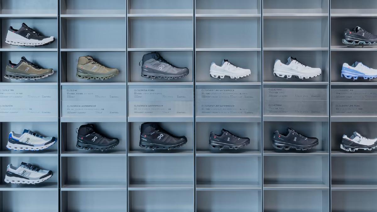 A variety of sports shoes on display shelves neatly arranged in rows and columns.