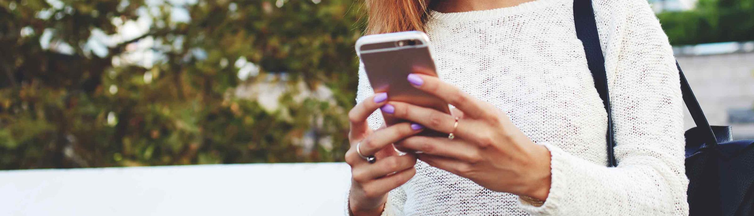 Primer plano de las manos de una persona sujetando un smartphone.