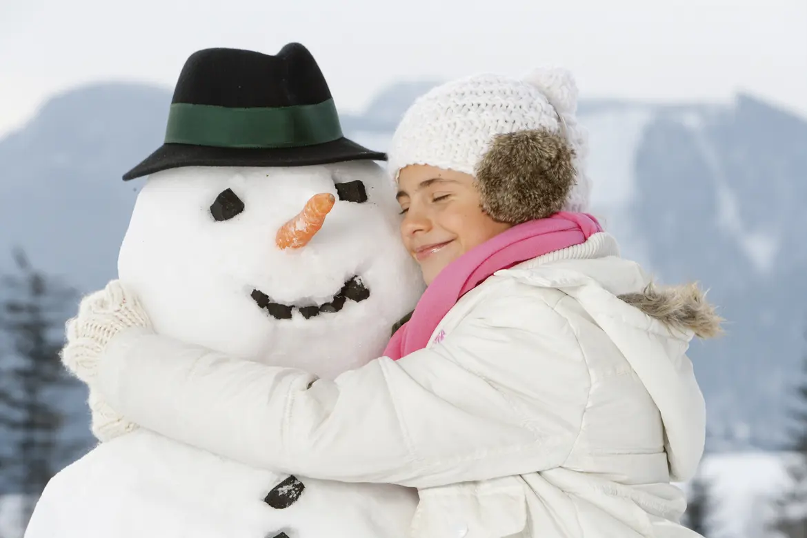 Mädchen umarmt Schneemann