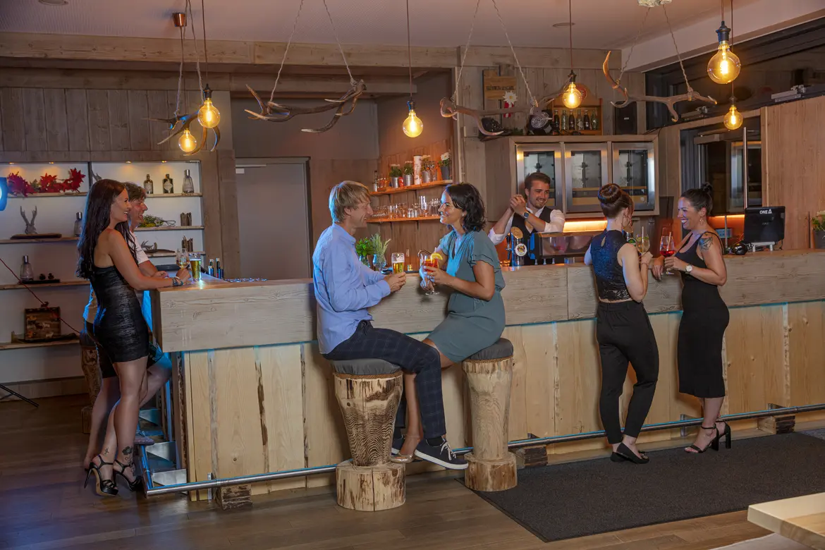 Leute nehmen Drinks im gemütlichen Stüberl