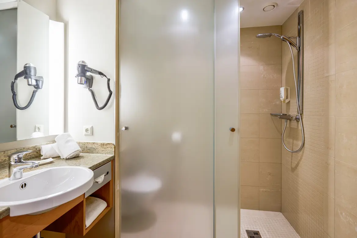 Badezimmer im Premium Cluburlaub von Aldiana mit Dusche, Waschbecken und Spiegel