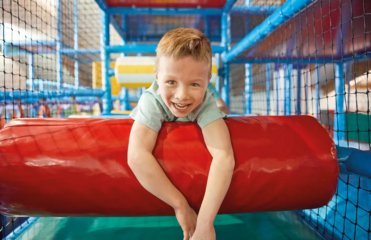 Ein Junge im Klettergerüst des Flosse Abenteuerlandes
