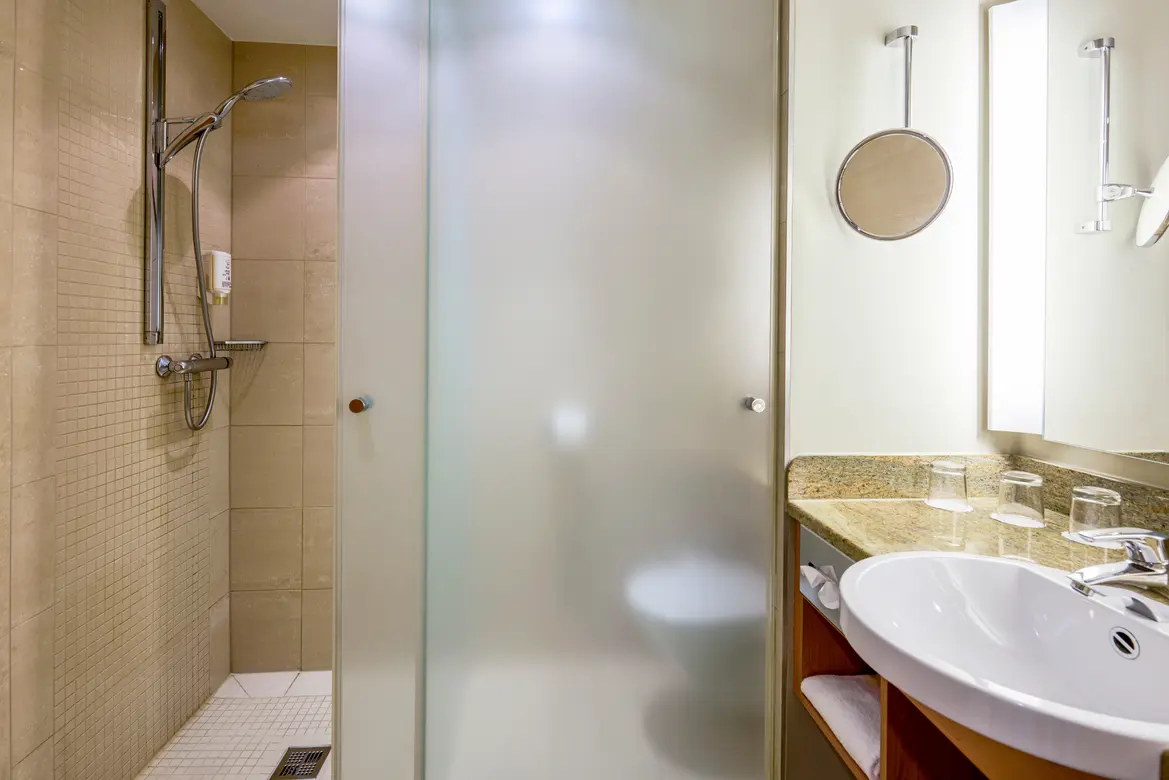 Badezimmer mit Dusche Waschbecken und großem Spiegel im Premium Cluburlaub bei Aldiana