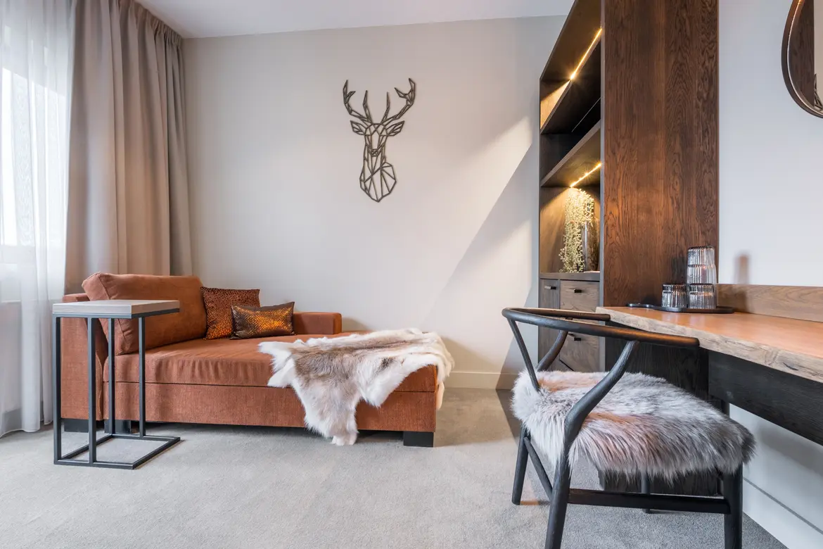 Moderne Hotelzimmer mit weißer Wand, Sofa und Holzregal, gemütliche Atmosphäre