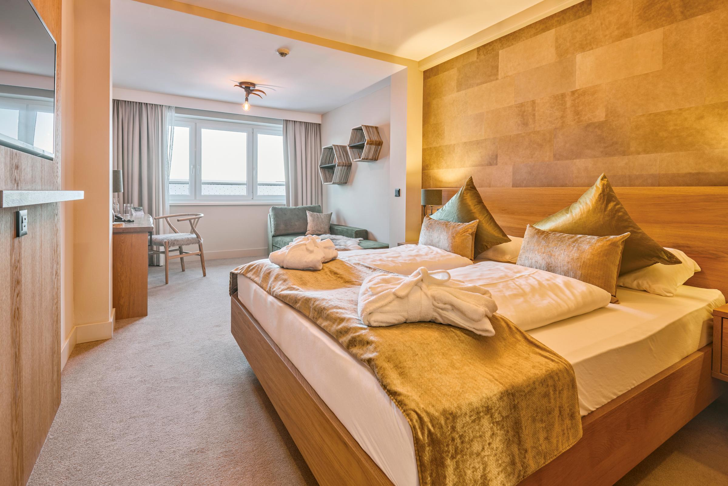 Elegant Hotelzimmer mit Doppelbett, Kissen und Blick auf Fenster und Sitzbereich