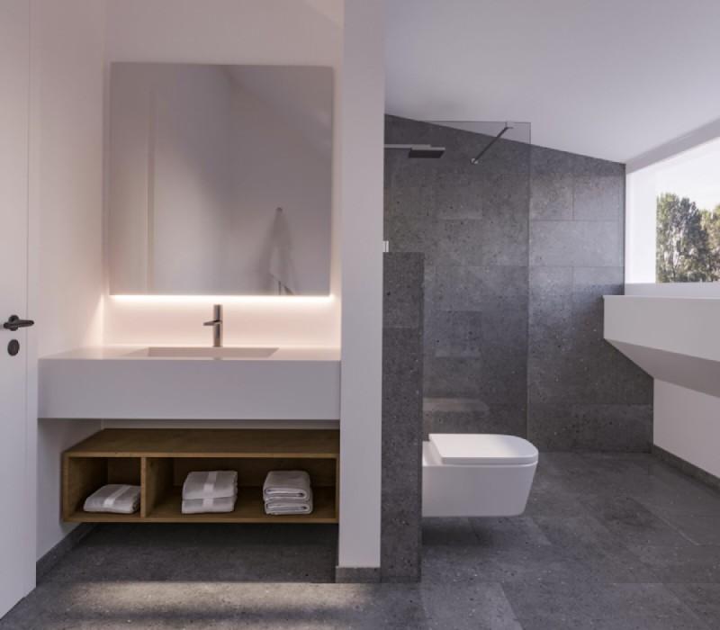 Modernes Badezimmer mit weißem Waschtisch, schlichter Toilette und grauen Fliesen der Einfamilienhäuser am Baselweg in Hochwald.