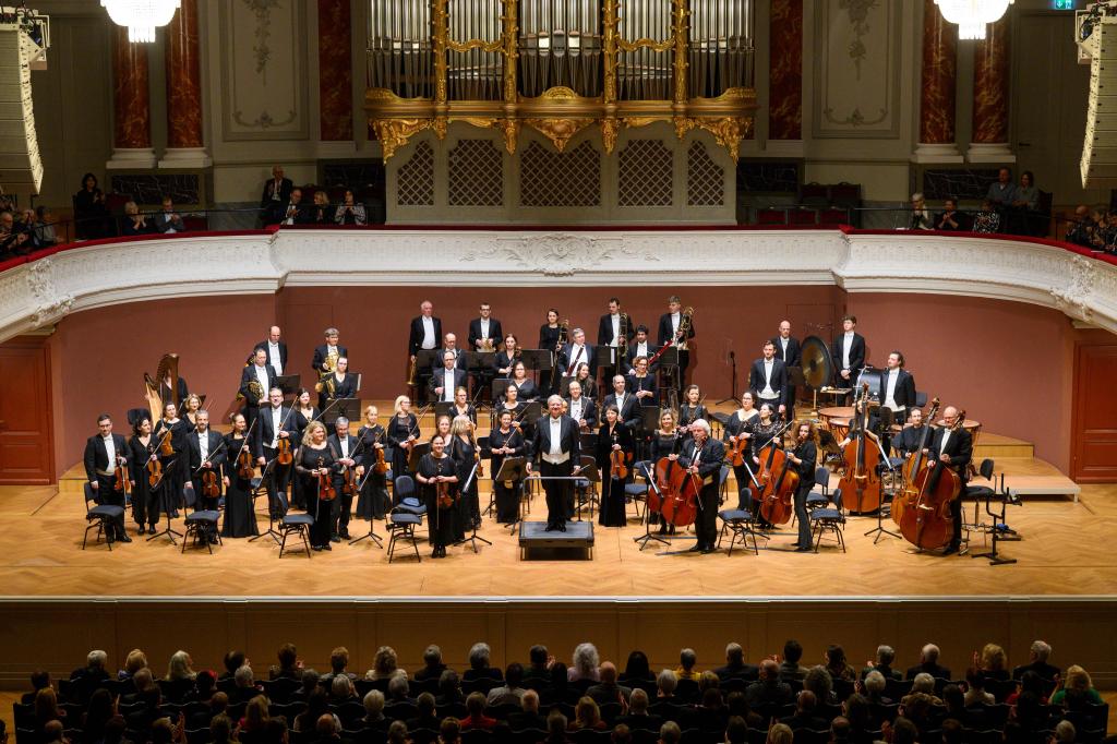 Orchester spielt live im Konzertsaal vor Publikum.