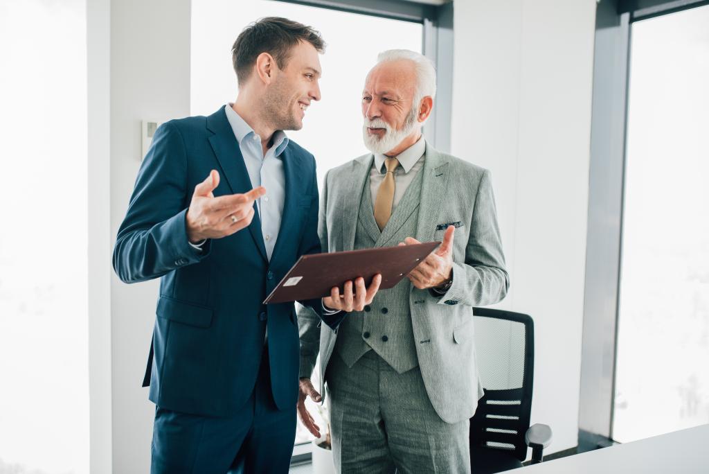 Smiling business men reading business paperwork