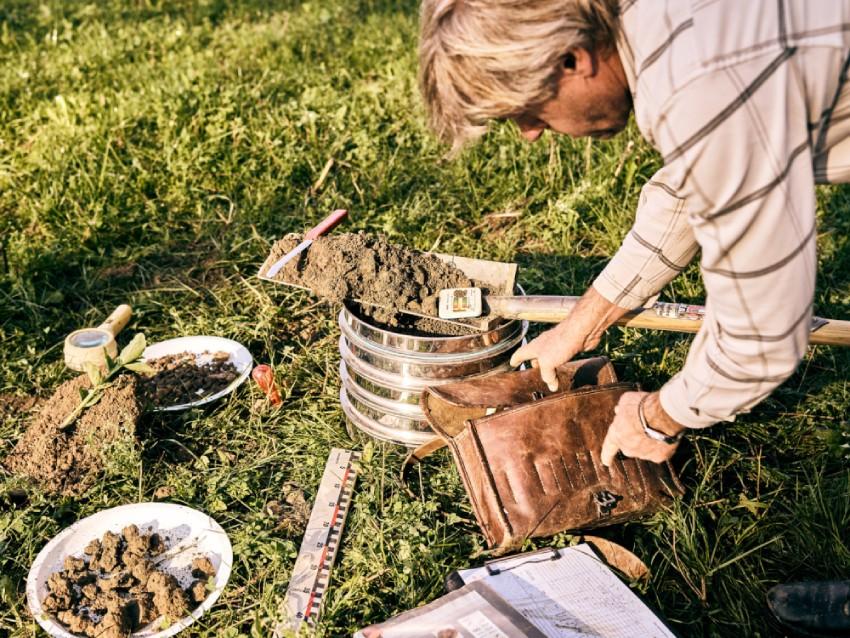 Ein Mann gräbt im Garten mit Werkzeugen und einer Blumentopf. aus dem Artikel CO₂ im Boden statt in der Luft – Zwischenbilanz