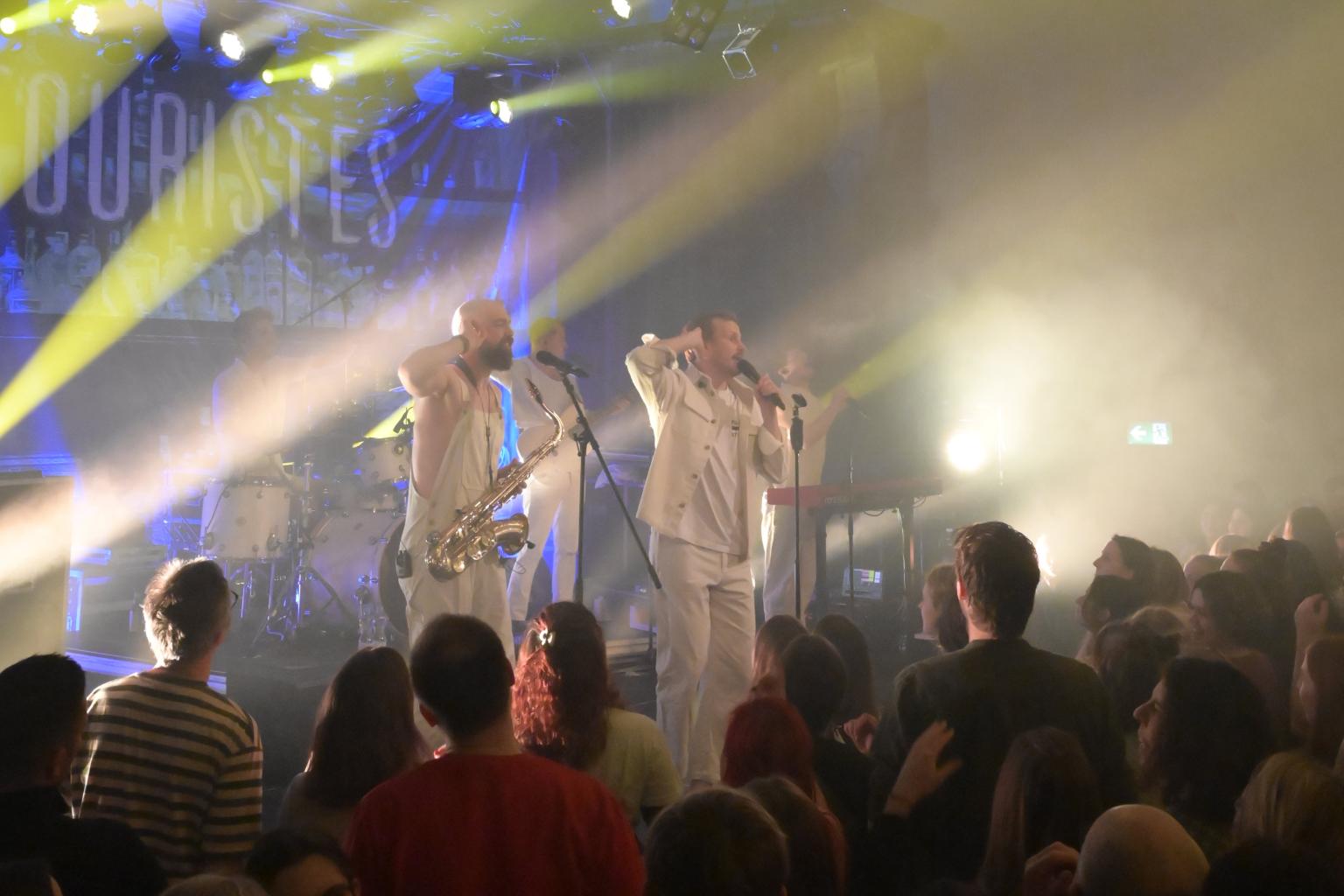 Musikperformer auf Bühne geben ein Konzert mit bunten Lichtern beim Theater Arlecchino.