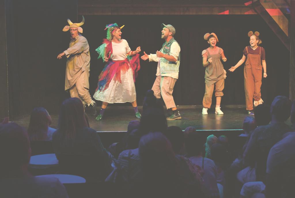 Kinder in Fantasiekostümen auf der Bühne, b Im Publikum.