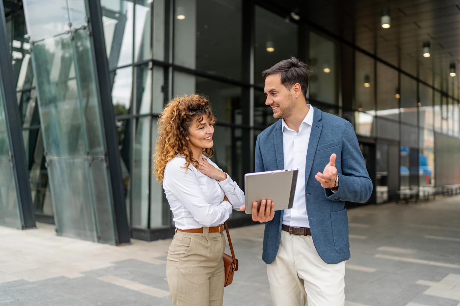 Zwei Personen im Gespräch vor dem Gebäude der Basellandschaftlichen Kantonalbank.