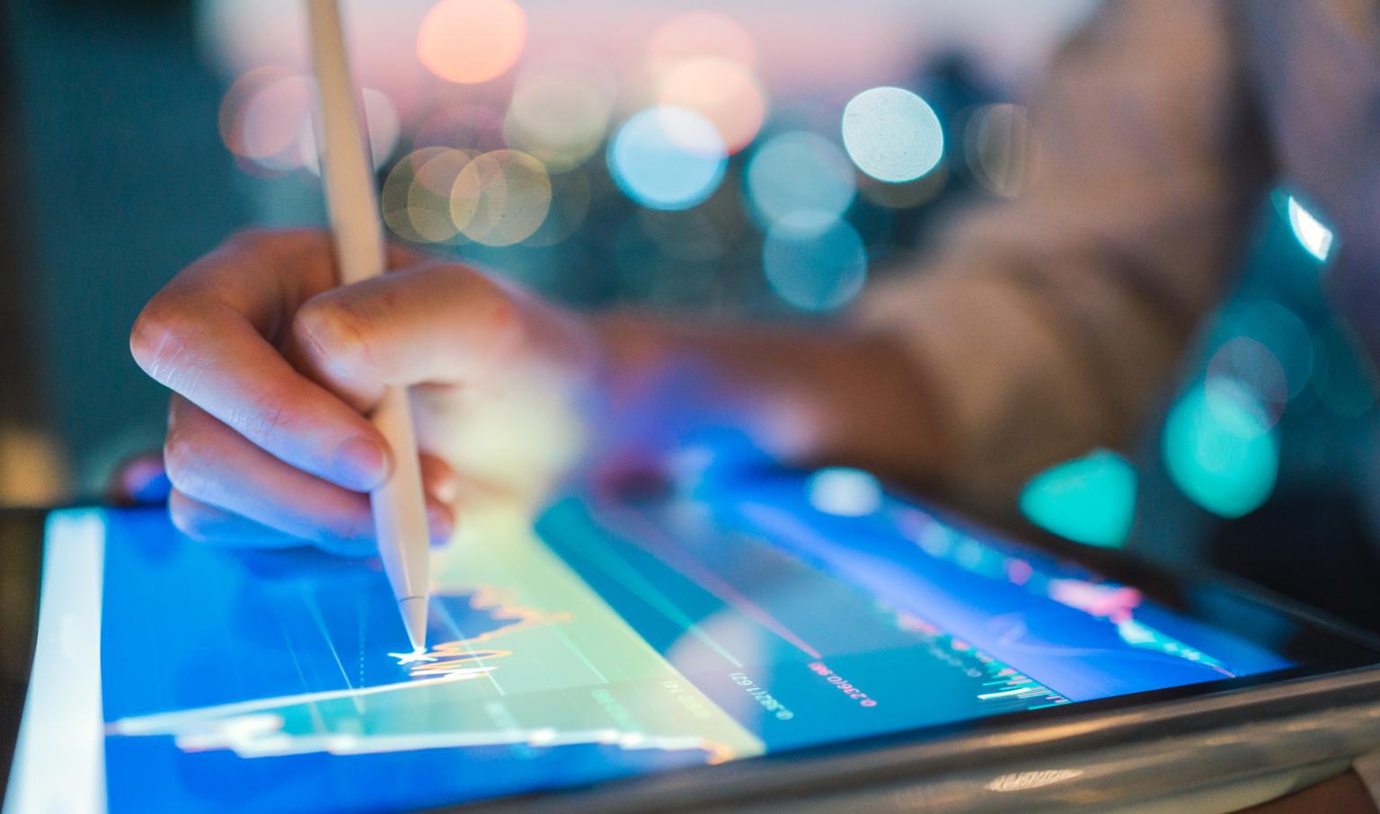 Person benutzt einen digitalen Stift auf einem Tablet der BLKB, im Hintergrund ein Diagramm aus dem Artikel Ein Arbeitstag im Asset Management