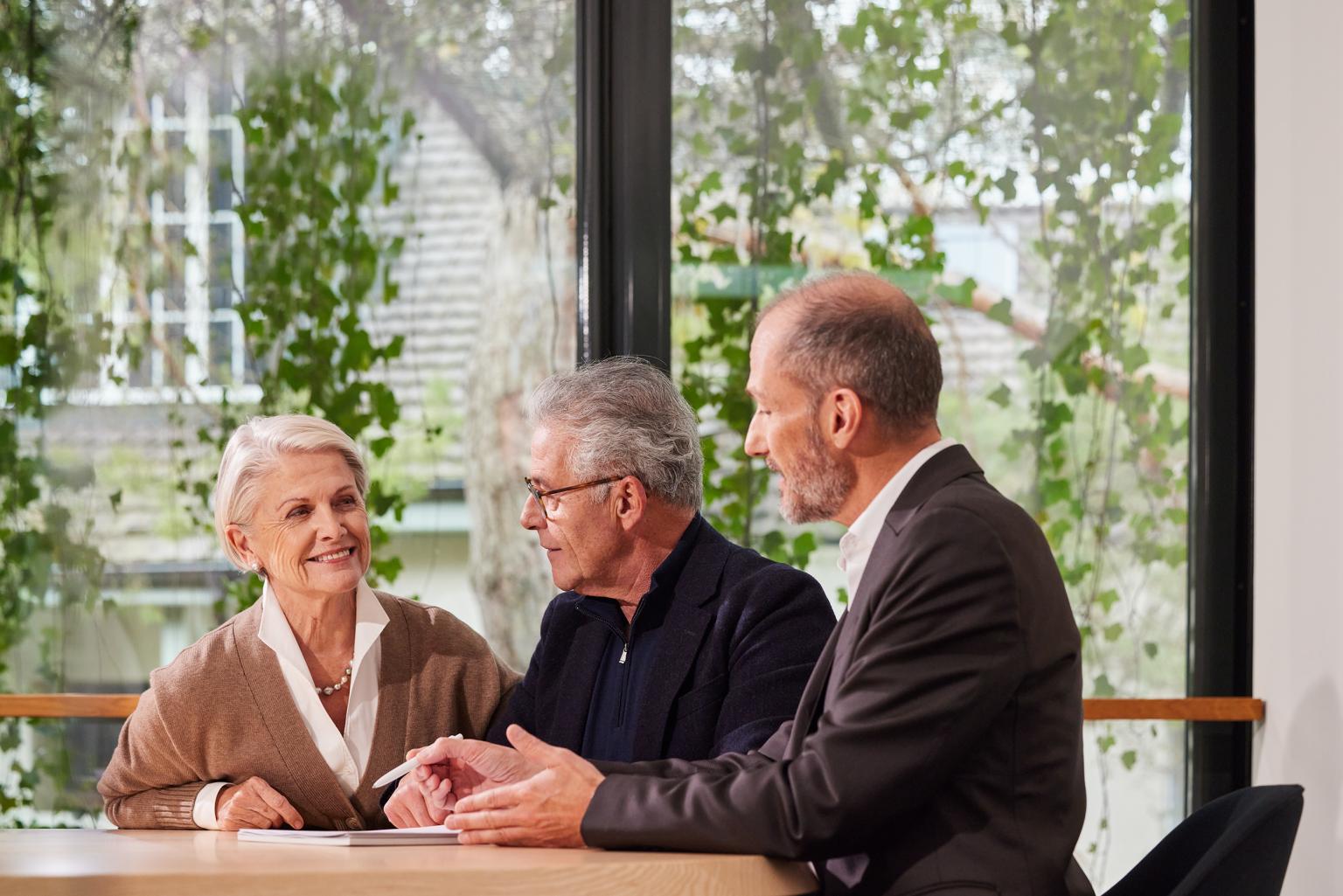 Drei Personen im Gespräch bei der Basellandschaftlichen Kantonalbank in einem modernen Raum aus dem Artikel Sicherheit und Transparenz in der Vermögensverwaltung
