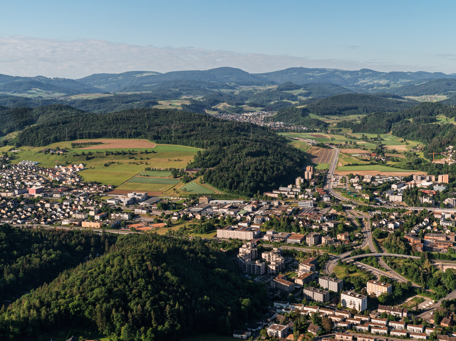 Landschaft mit Hügeln, Feldern und einer Stadt, aufgenommen bei Tageslicht