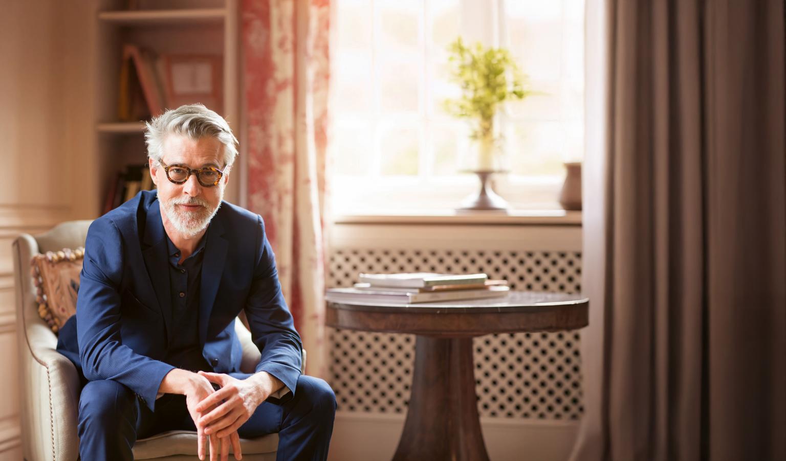 Begrüßungsperson in einem stilvollen Raum mit natürlichem Licht und warmen Farben