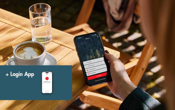 Frau mit Kaffee und Wasser schaut die E-Banking App an.