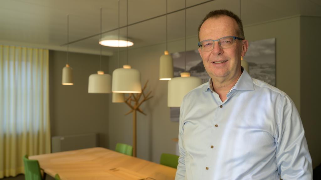 Geschäftsraum der Basellandschaftlichen Kantonalbank mit modernen Lampen und dekorativem Baum