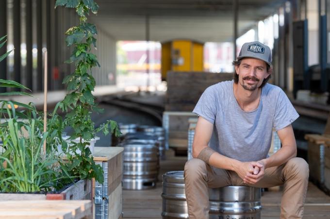 Young man from Birtel with white cap sitting on a beer barrel.