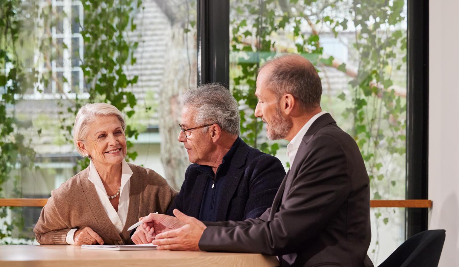 Drei Personen diskutieren freundlich bei der Basellandschaftlichen Kantonalbank