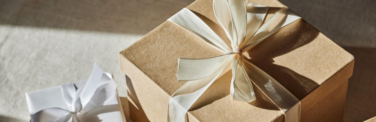 Braune und weisse Geschenkverpackungen in Papier und Schleifen, festlich präsentiert.