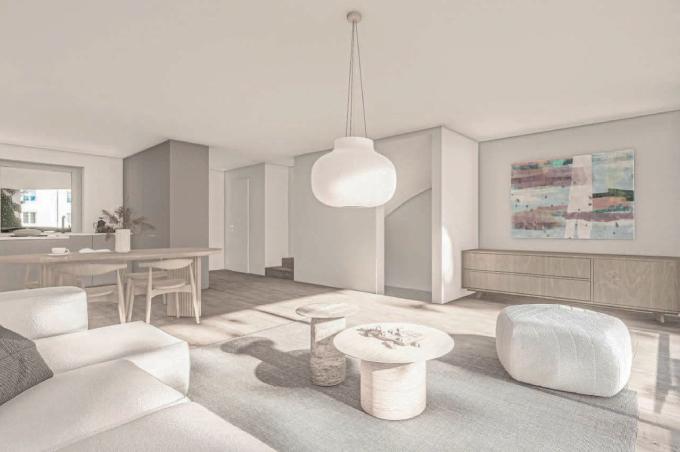 Weisses Wohnzimmer mit Sofa, Esstisch, Stühlen und Küche im Sonnengarten in Bättwil