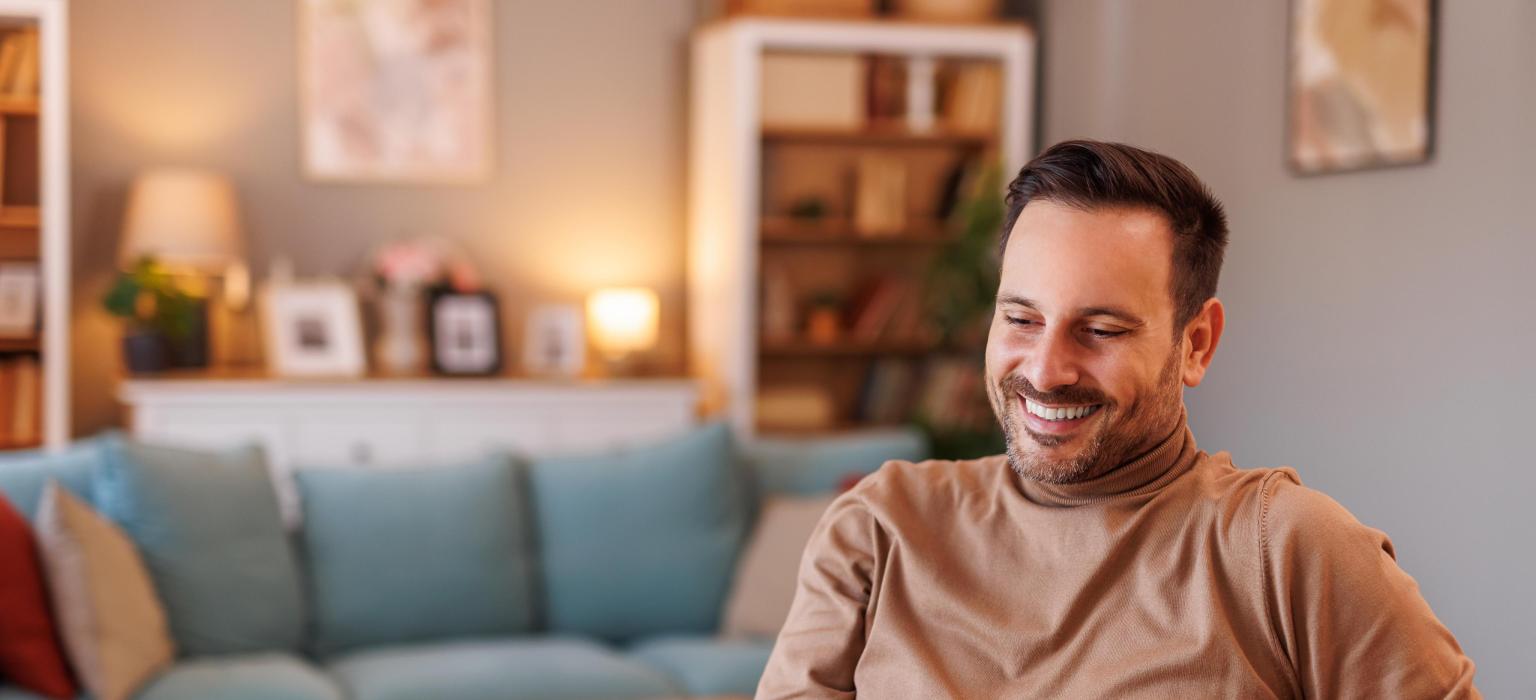 Moderne Wohnzimmerszene mit Person, angenehmer Atmosphäre und BLKB Werbung im Hintergrund