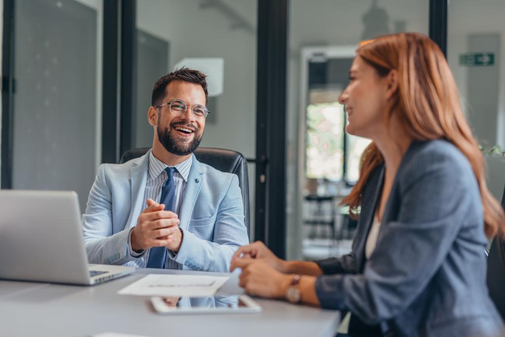 Zwei Personen im Gespräch bei einer Bankberatung in einem modernen Büro.