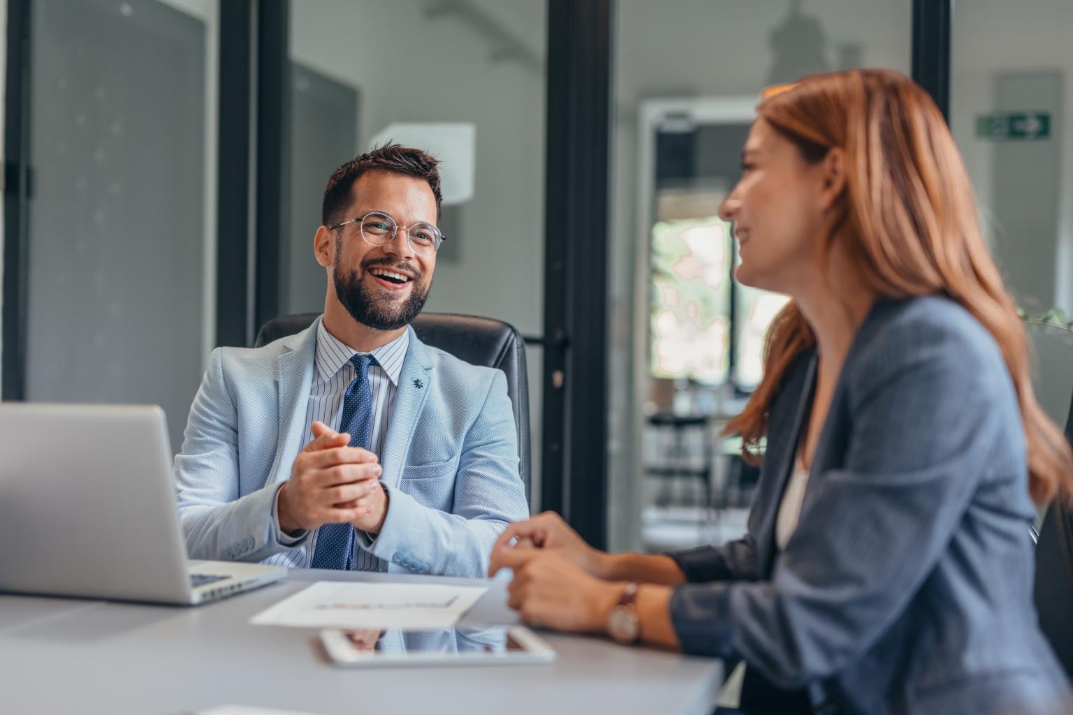 Zwei Personen im Gespräch bei einer Bankberatung in einem modernen Büro. aus dem Artikel Sustainable Asset Management als Profidienstleister