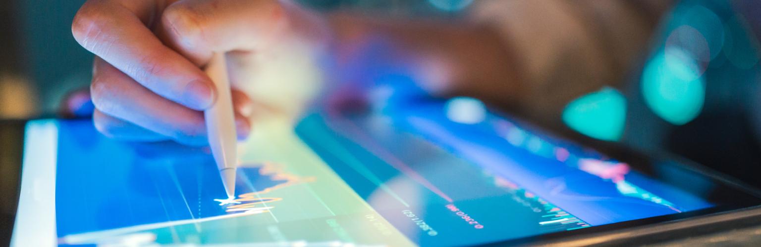 Person benutzt einen digitalen Stift auf einem Tablet der BLKB, im Hintergrund ein Diagramm