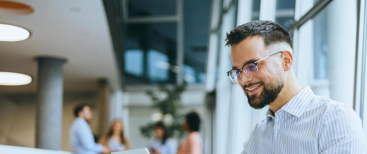 Mitarbeiterin bei der BLKB im Gespräch in moderner Bankumgebung