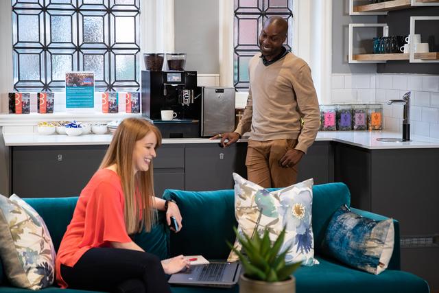 Customers talking in the communal kitchen / lounge area