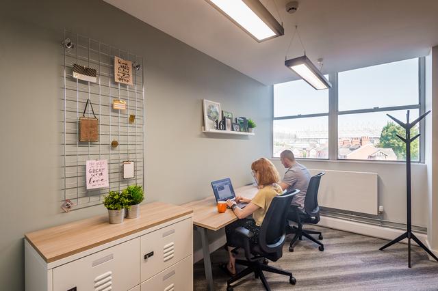 two colleagues working on laptops