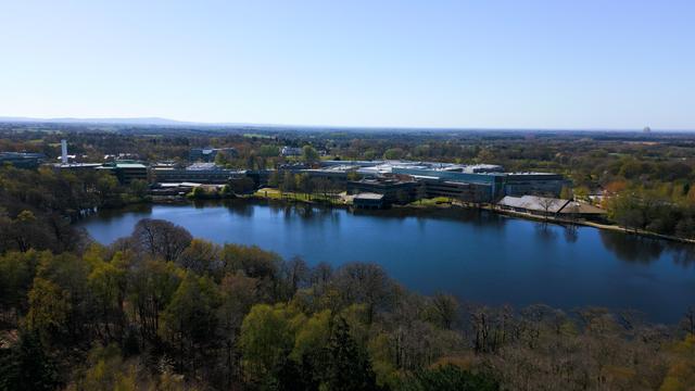 Aerial view of lake with surrounding low office buildings and trees