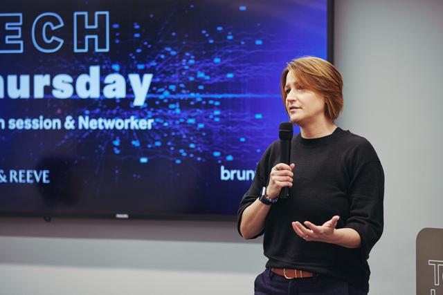 deb hetherington in front of tech thursday sign