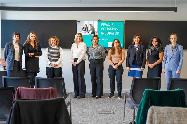female business owners standing in line at the front of a room