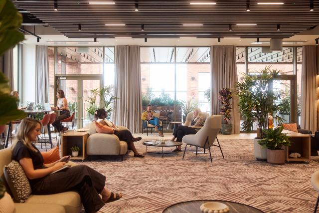 Two people walk through No.3 Circle Square's ground floor reception / lounge space