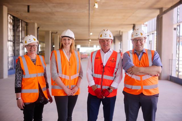 People in high visibility vests and hard hats on fifth floor of Greenheys development