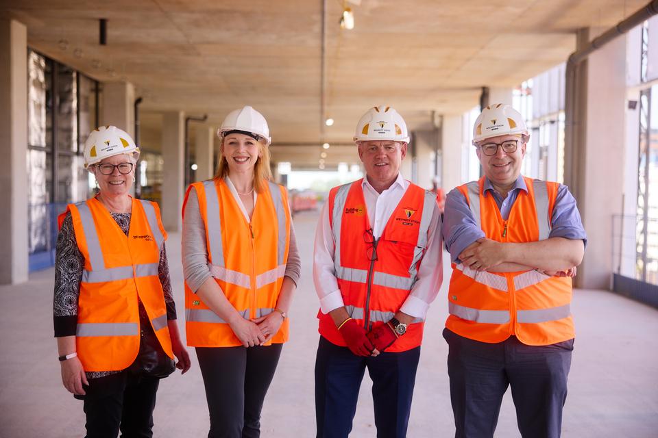 People in high visibility vests and hard hats on fifth floor of Greenheys development