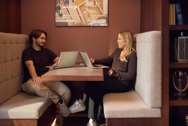 Two men talking at a hot desk