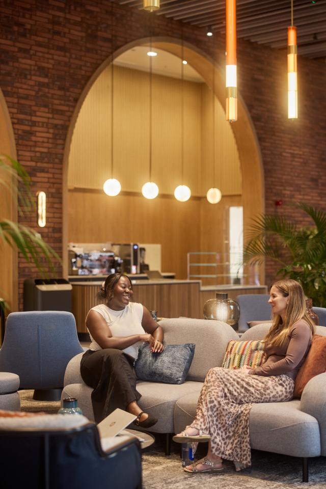 Two people chat on a sofa in No.3 Circle Square's ground floor reception / lounge area