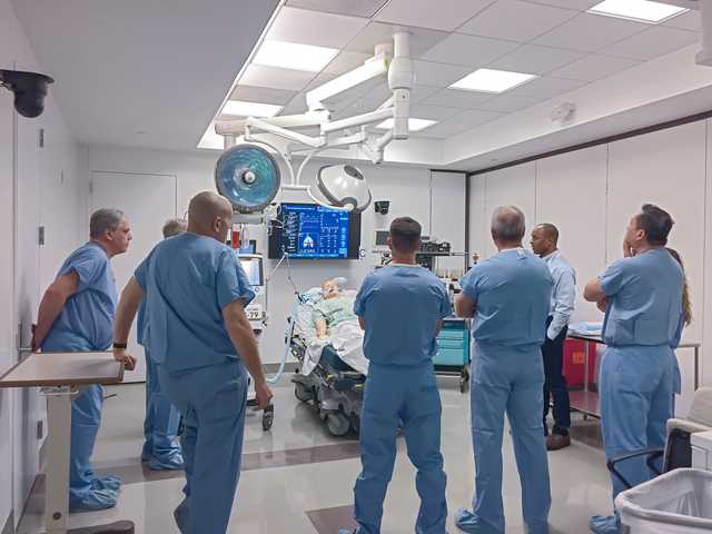 Medical personnel around a patient speaking together