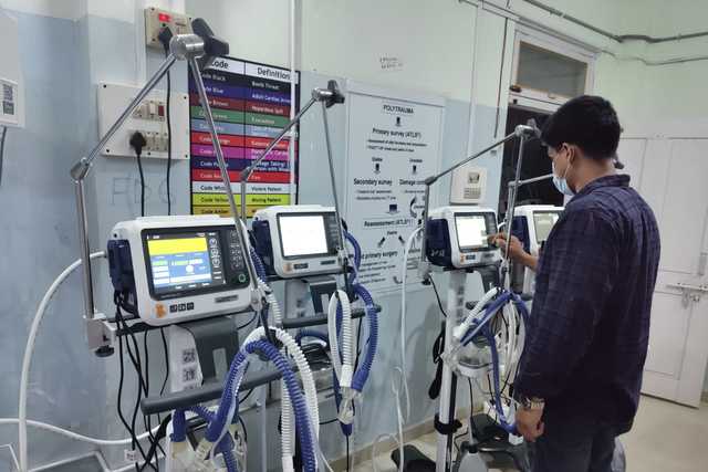 Dipendente in piedi davanti ai ventilatori HAMILTON-C1 nel reparto di terapia intensiva