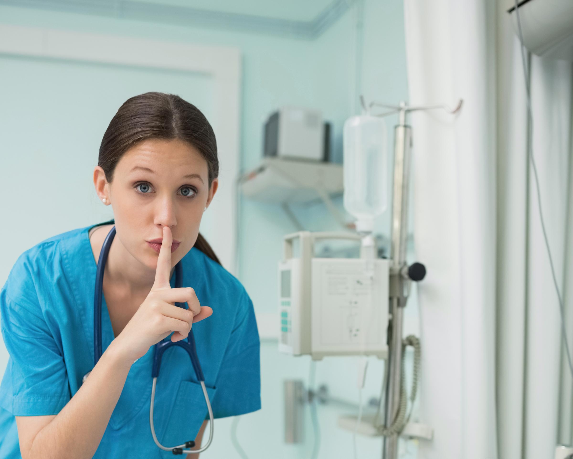 Infermiere che fa il tipico gesto per chiedere di fare silenzio