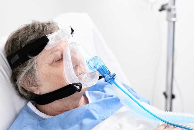 Пациент в маске для неинвазивной вентиляции