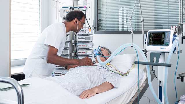 Medizinische Fachkraft und Patient mit NIV-Maske