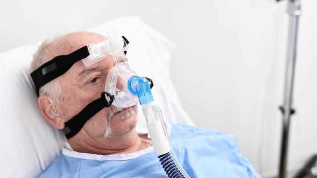 Patient in bed wearing nasal mask